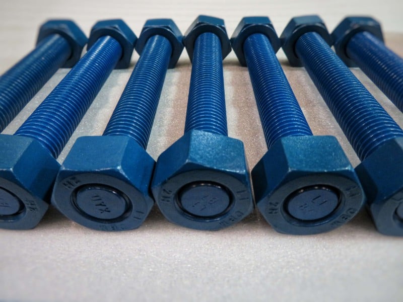 Fluoropolymer coated bolts for torque value
